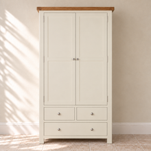 Cambridge Classic Cream Painted Oak Larder Unit with closed doors, oak top and silver handles against an ivory wall and limestone floor